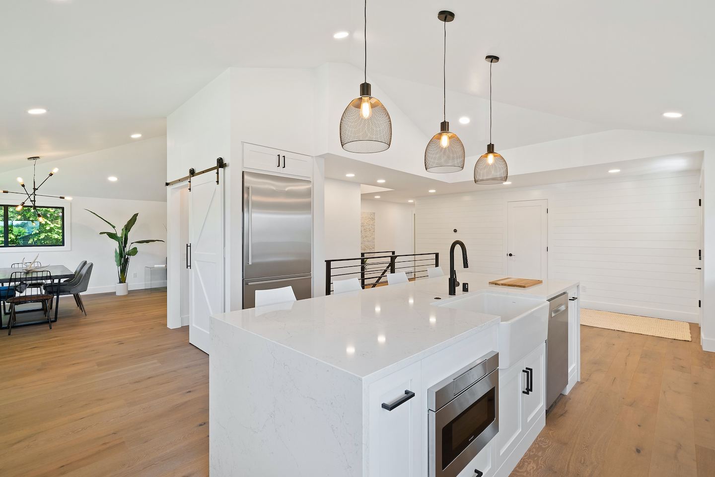 Kitchen area with three pendant lights, a chandelier, and multiple recessed lights.