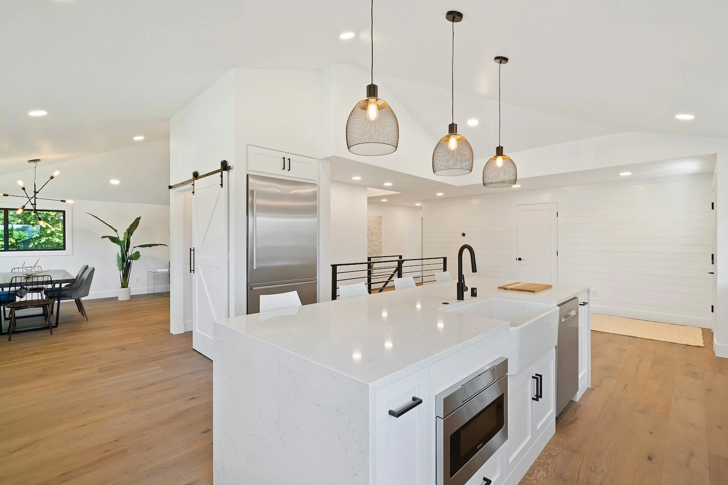Kitchen of home in Del Valle with white countertops and three pendant lights.