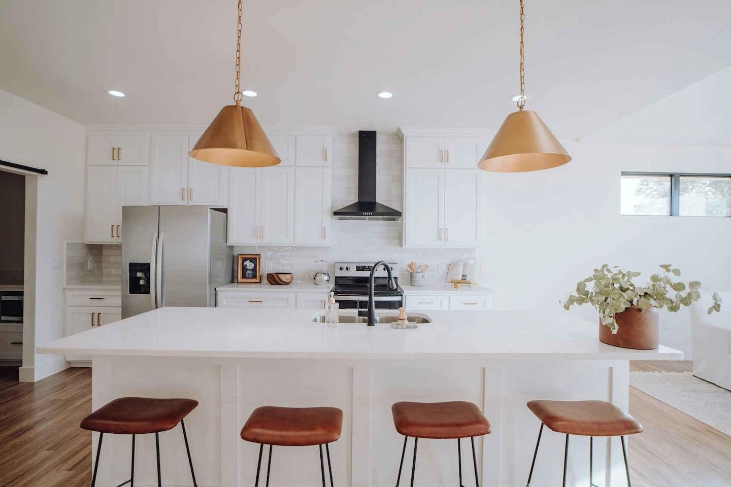 Home in North Austin with white countertops, brown barstools, and copper pendant lights.