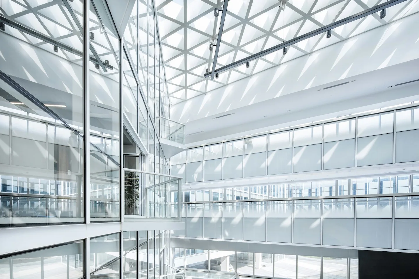 Large office building with glass windows and glass railings.