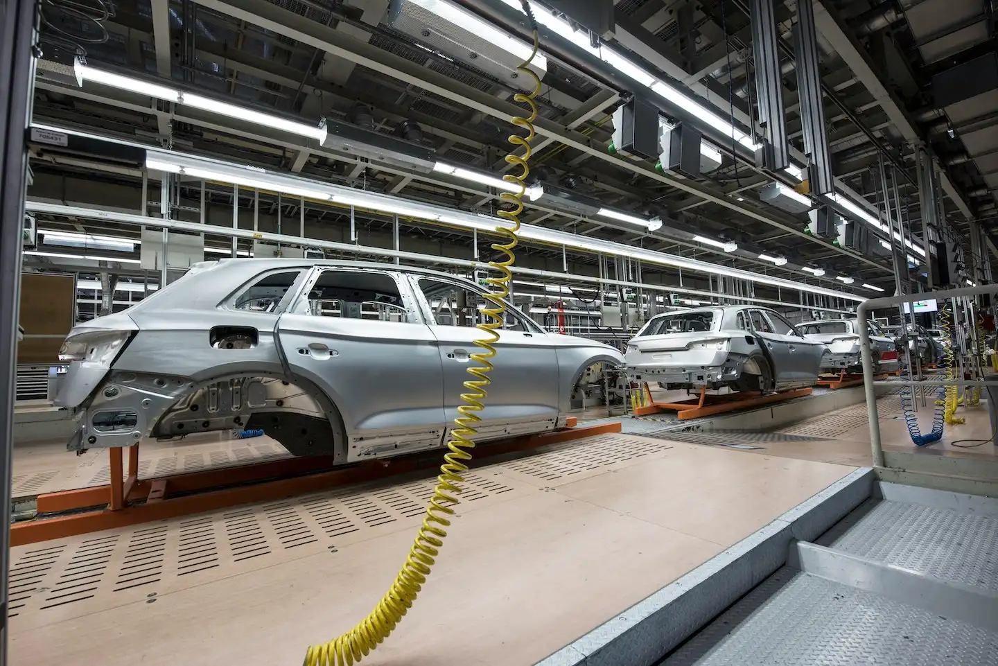 Automobile manufacturing facility with cars on the assembly line.