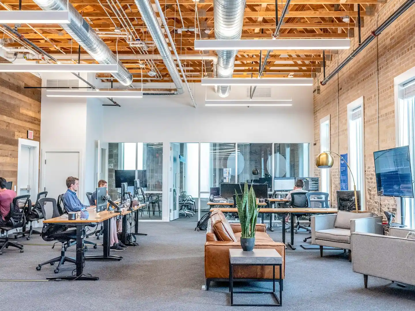 Open workspace with desks, computer monitors, and a casual sitting area.